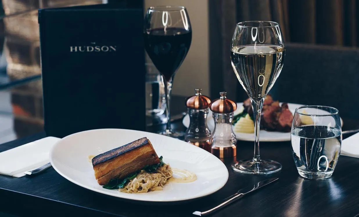 a plate of food and glasses of wine on a table at The County Aparthotel in Newcastle upon Tyne